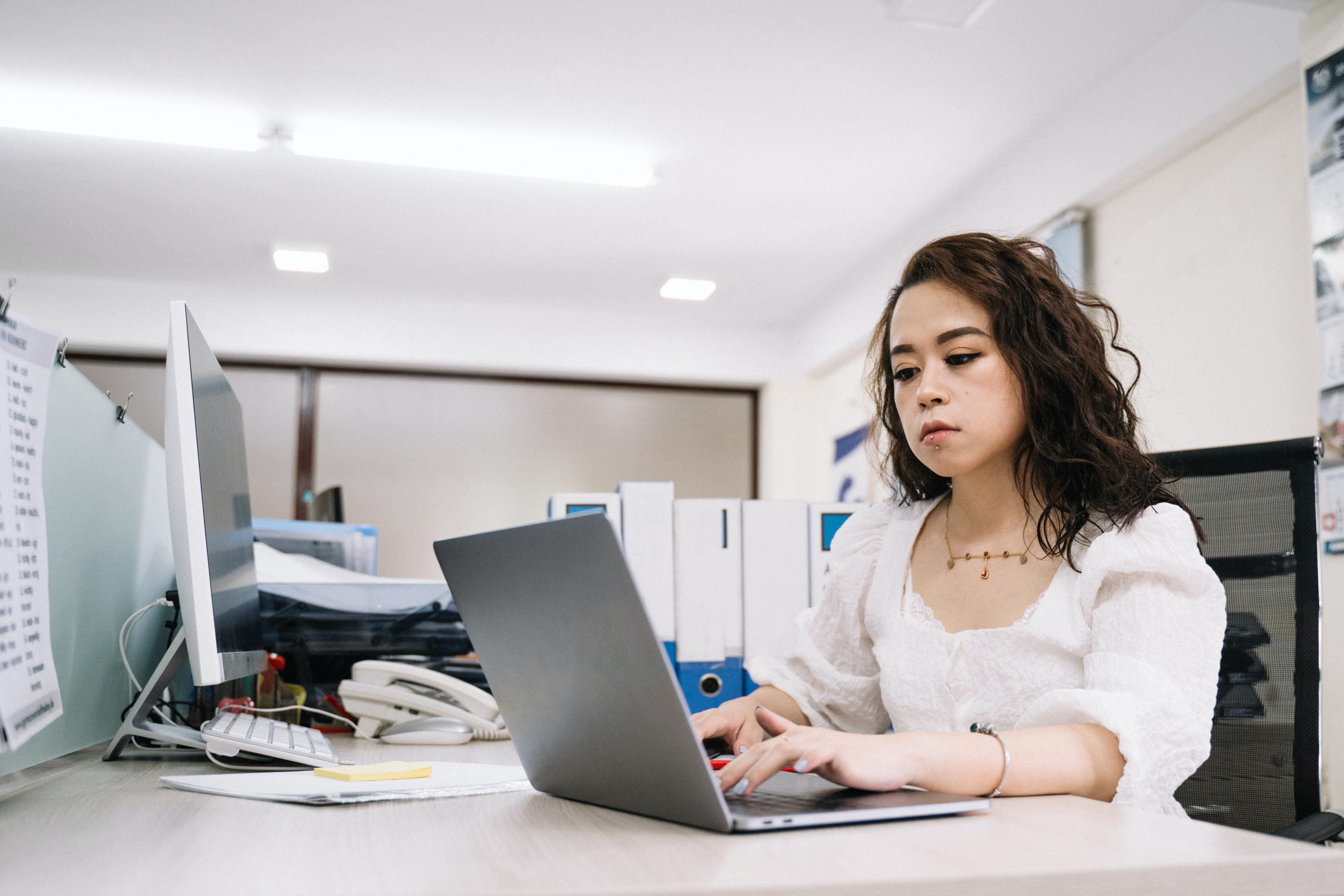 Mulher Com Camisa De Renda Branca Usando Macbook Pro