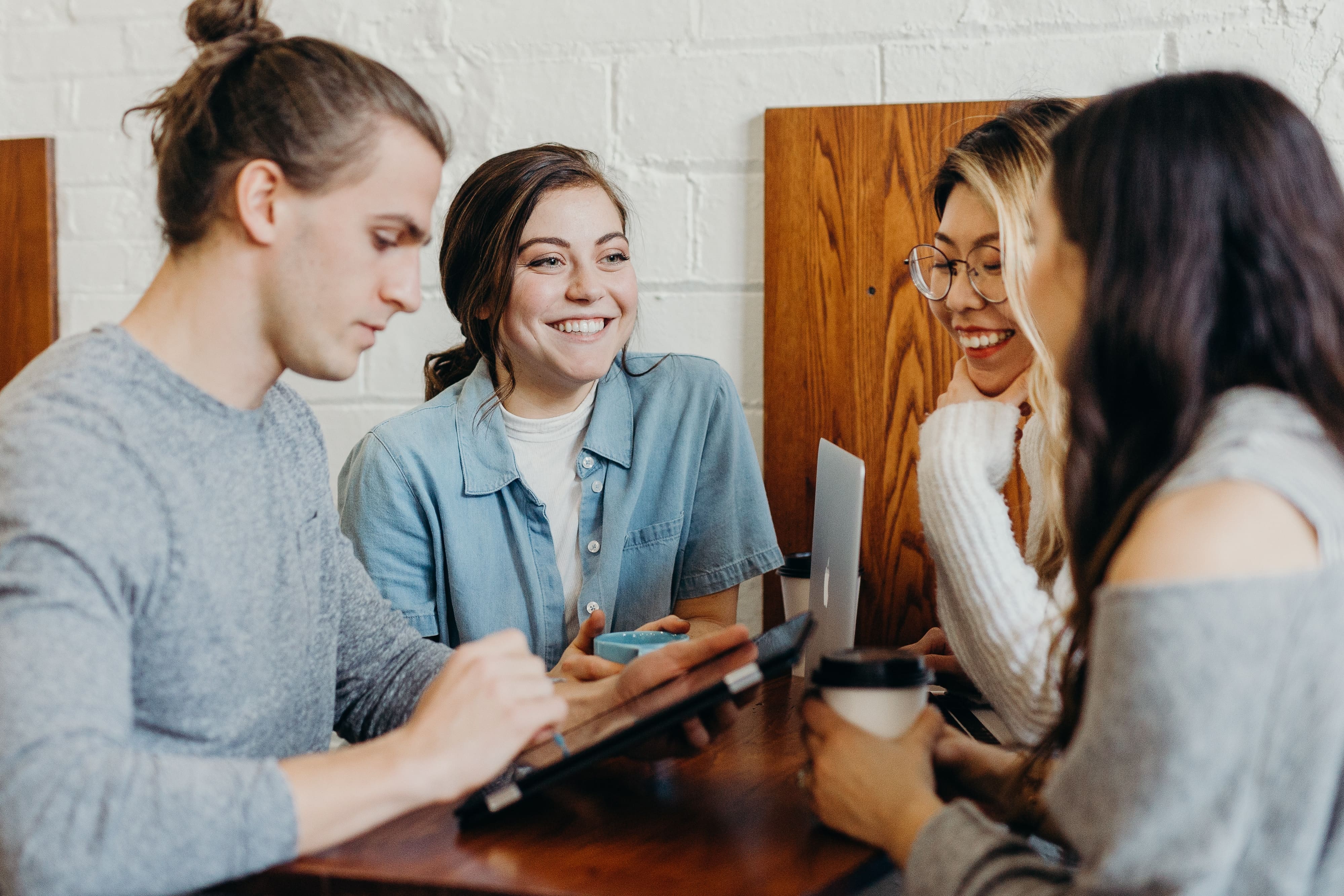 pessoas em conjunto se apoiando na mesa e conversando